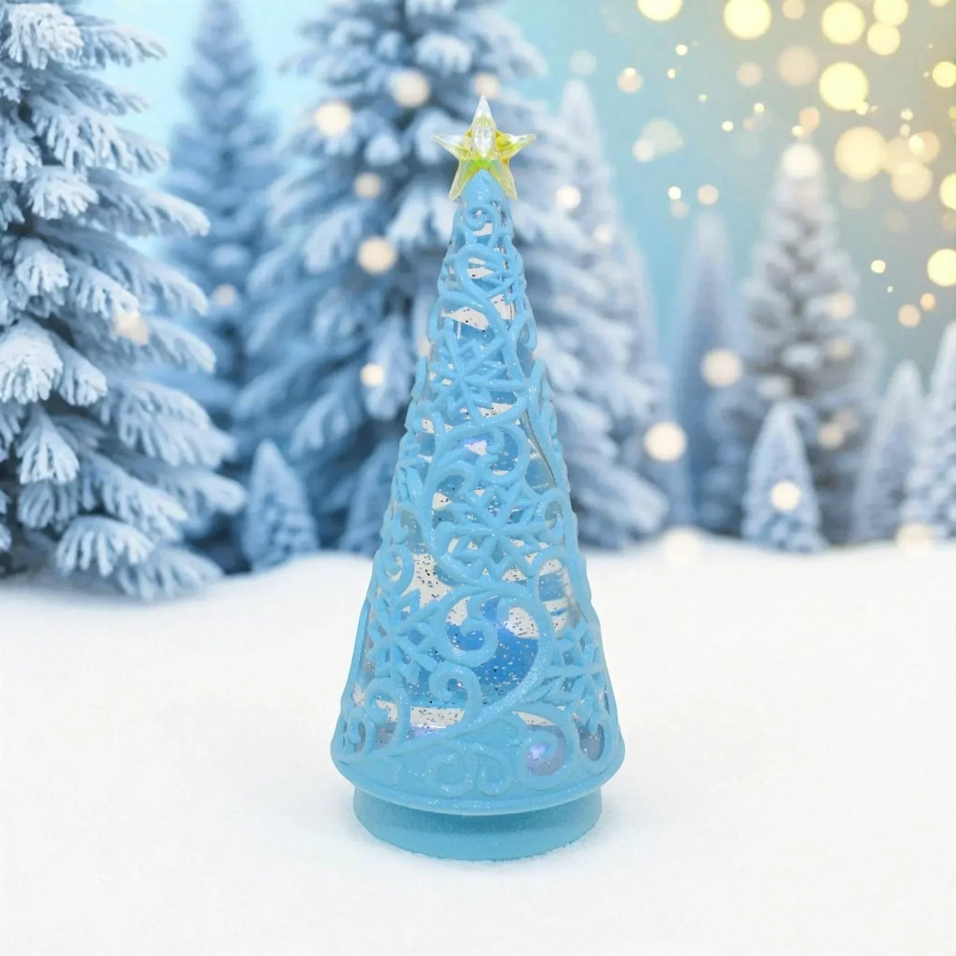Blue ornate Christmas tree decoration with star topper, set in snowy winter scene