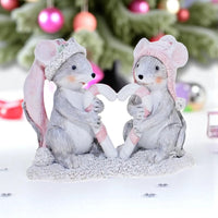 Charming mouse figurines in winter hats holding candy canes, festive holiday décor with Christmas tree background