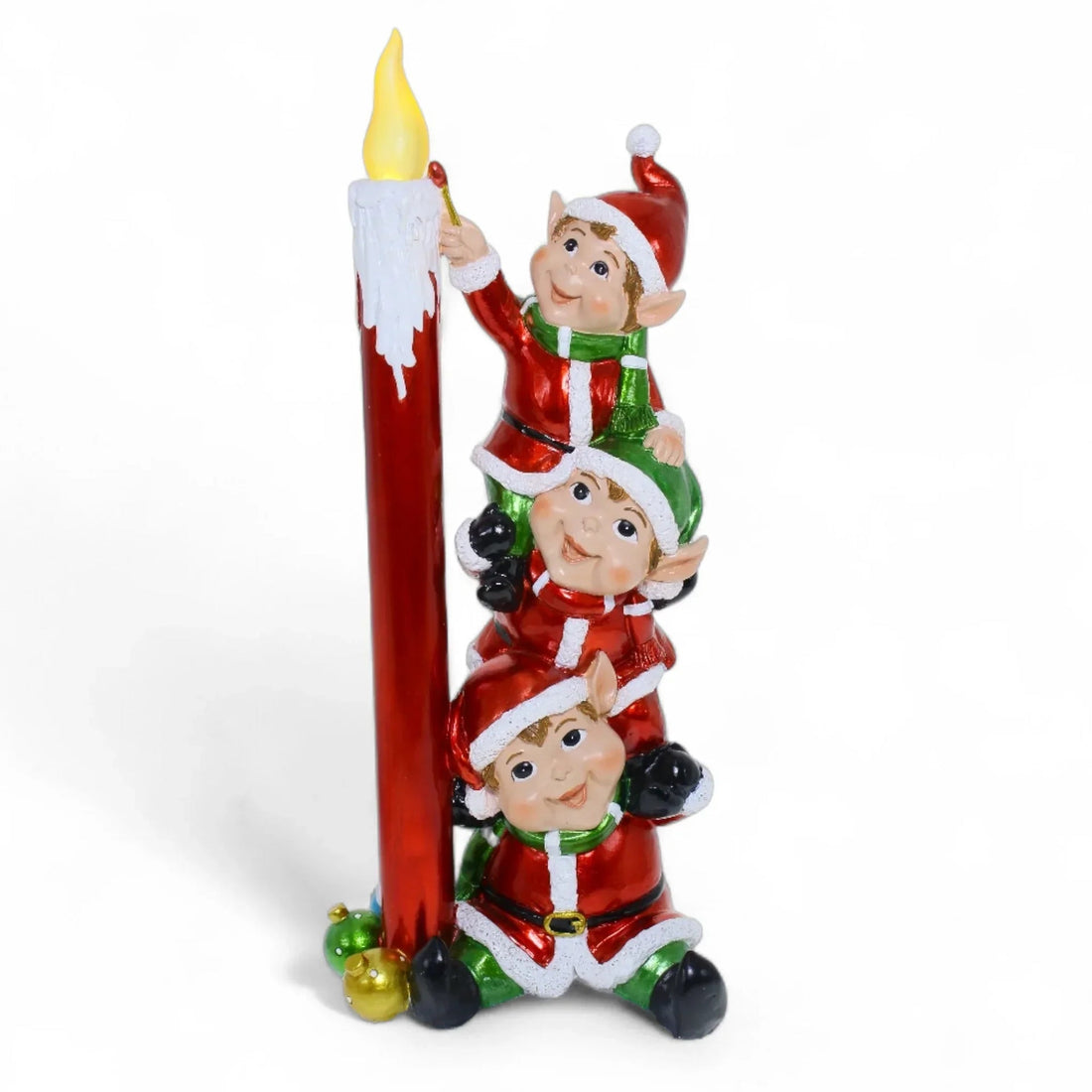 Three festive elves in red and green climbing a tall red candle, holiday home décor accent