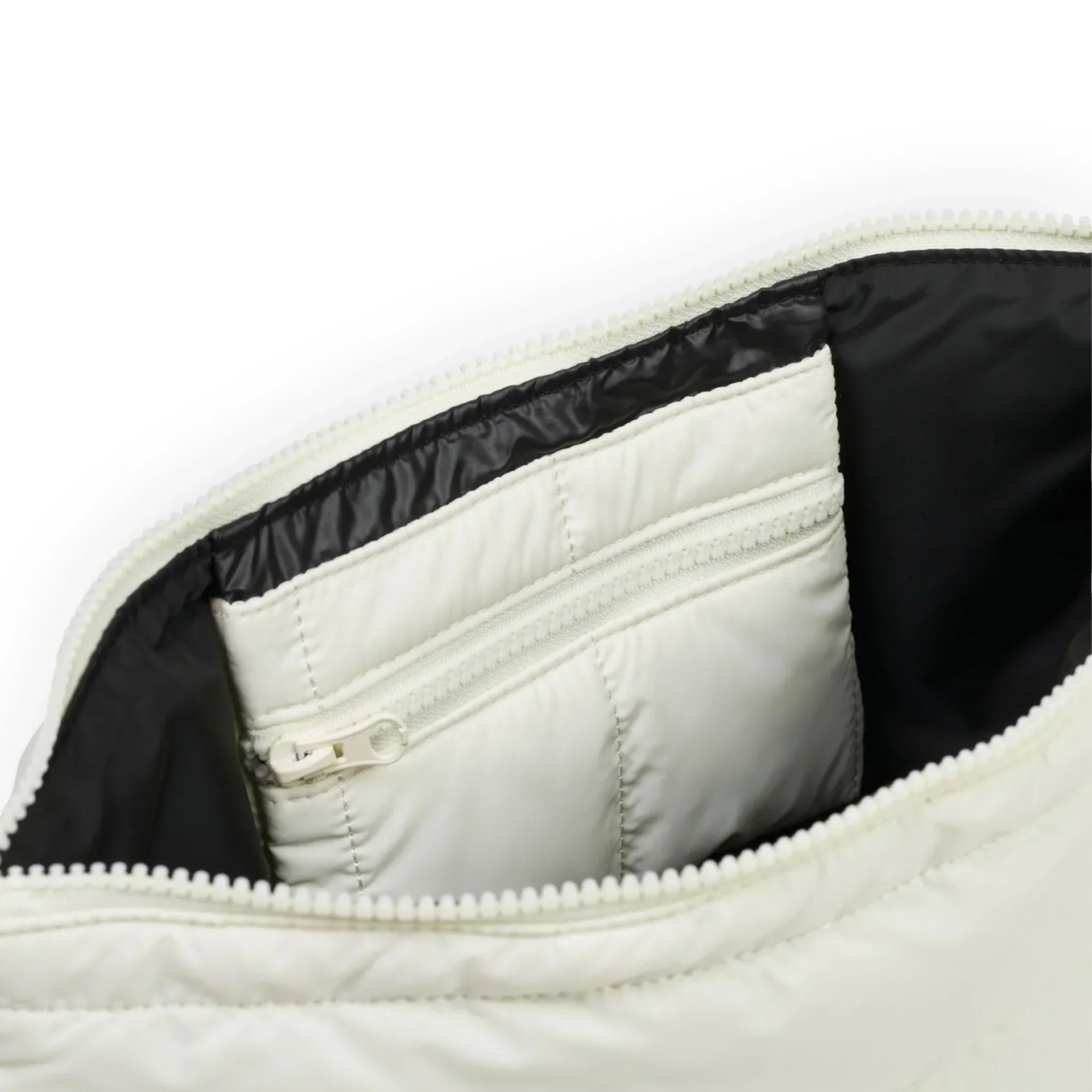 Cream quilted bag interior with black lining and zippered pocket, premium home accessory