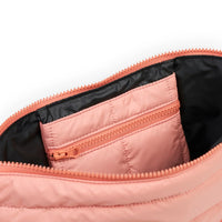 Pink quilted bag interior with black lining and zippered pocket, showcasing organized storage design