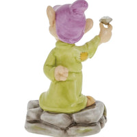 Ceramic gnome figurine in green robe and purple hat, holding a gem, perched on stone base for home décor