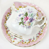 Elegant floral teacup and saucer set with pink polka dots and gold trim, perfect for home decor