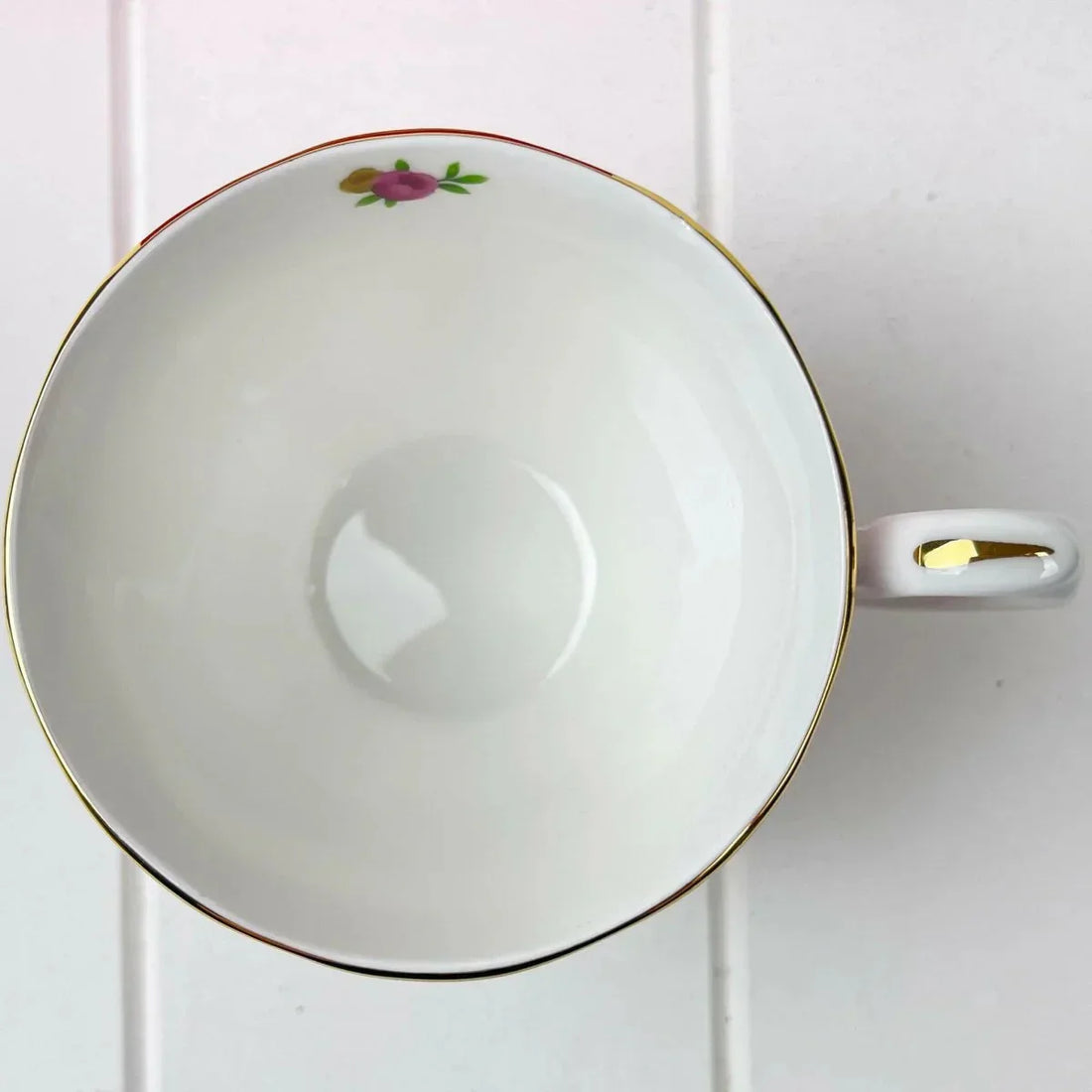 Elegant white teacup with gold rim and floral design, perfect for home decor