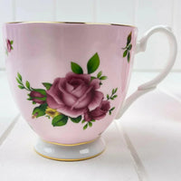 Pink ceramic teacup with purple rose floral design and gold trim, elegant home decor accent