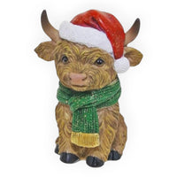 Adorable Highland cow figurine wearing red Santa hat and green scarf, festive Christmas home decor