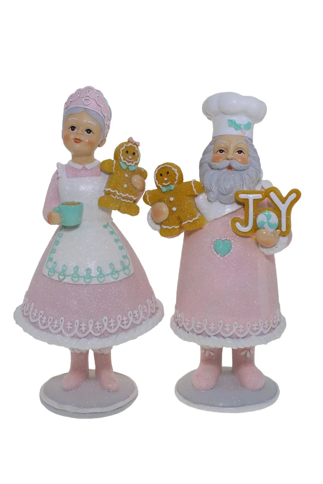 Pink glitter Santa & Mrs Claus figurines holding gingerbread cookies and JOY sign, festive holiday home decor